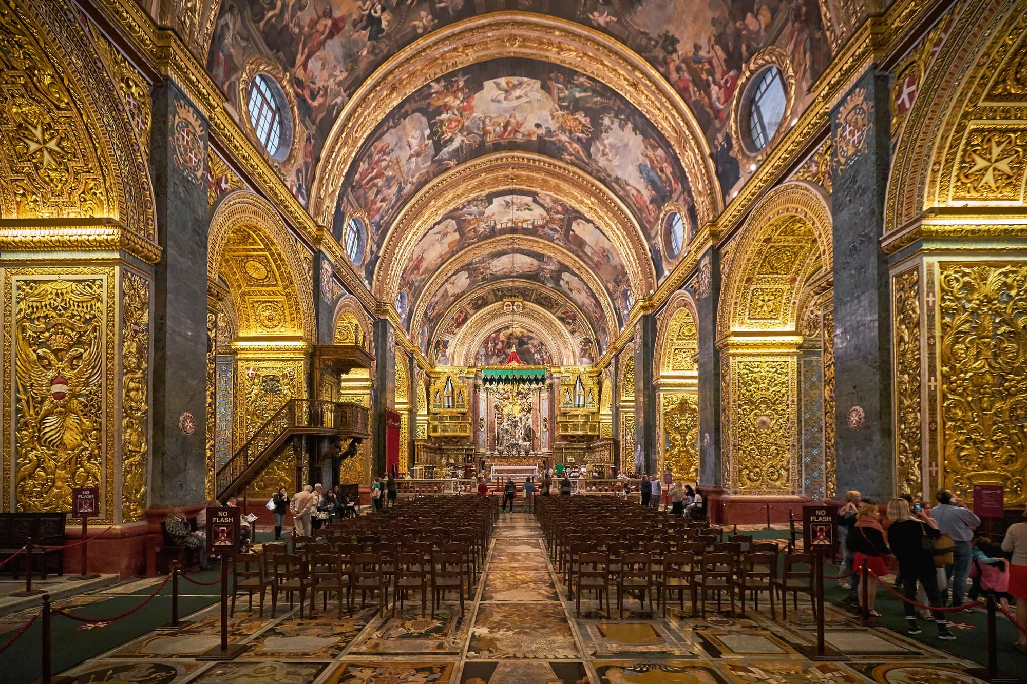 The gilded nave of St John's Co-Cathedral, its vaulted ceiling painted end to end.