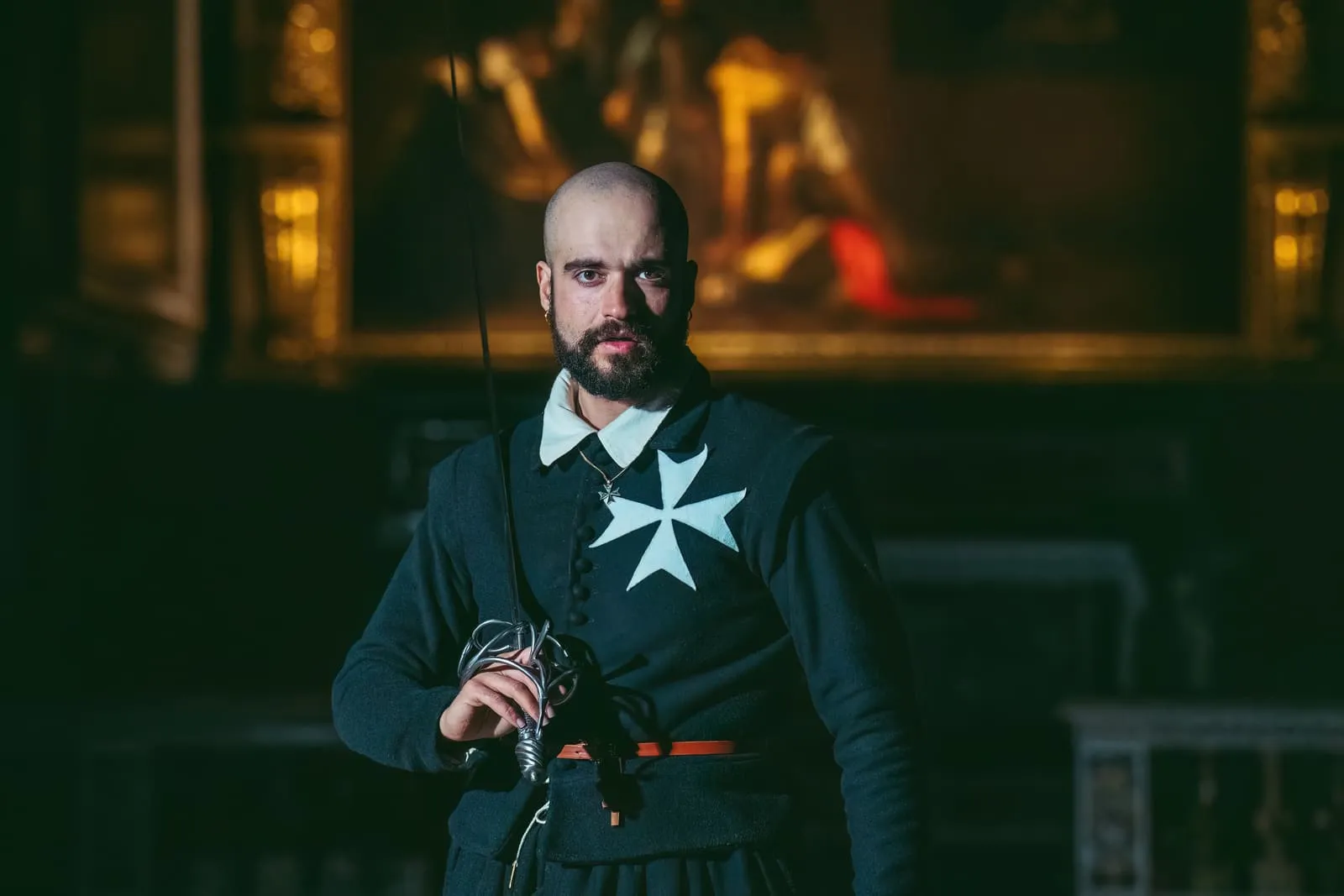 The character of Fra Bartolomeo, in the black robe and eight-pointed cross of the Order, narrating in the candlelit Oratory.