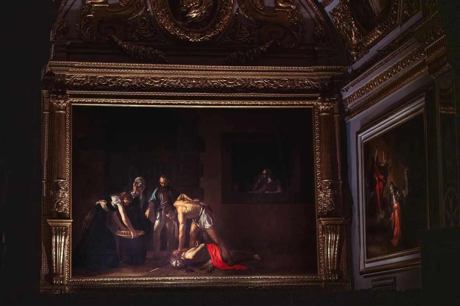 Caravaggio's Beheading of St John the Baptist under the performance lighting installation, the rest of the Oratory in darkness.